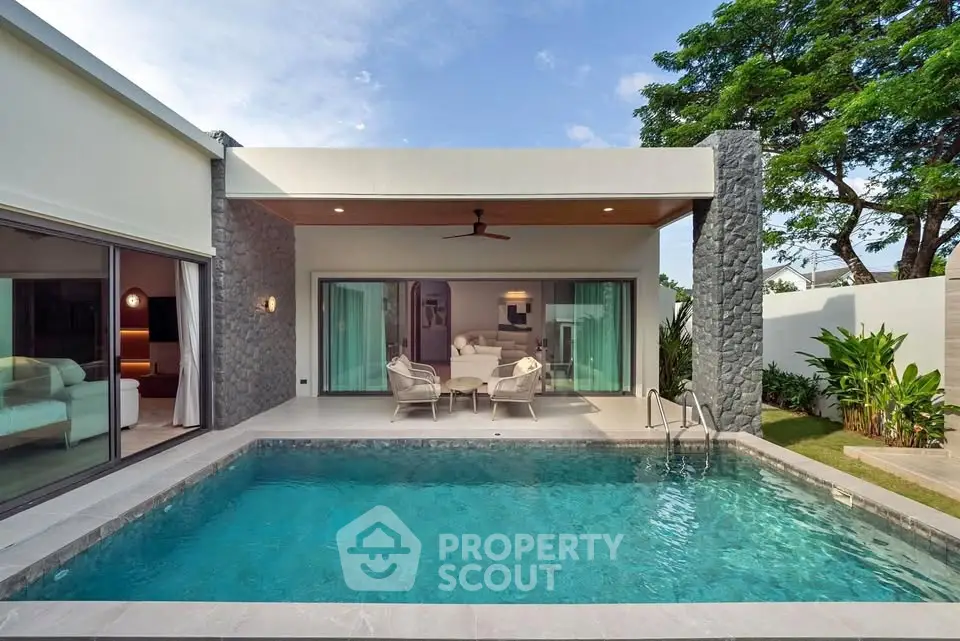 Luxurious modern villa with private pool and elegant outdoor seating area.