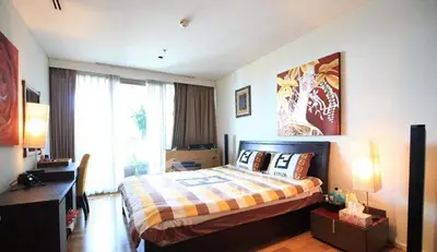 Spacious bedroom with modern decor and large window for natural light.