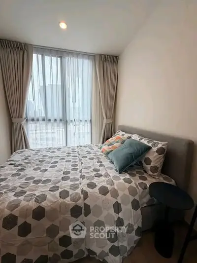 Cozy bedroom with modern decor and large window for natural light