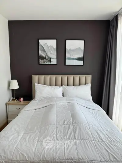 Cozy bedroom with elegant decor and natural light, featuring a plush bed and stylish artwork.