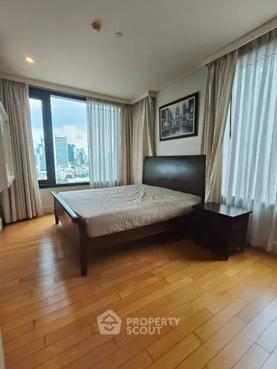 Spacious bedroom with city view and elegant wooden flooring