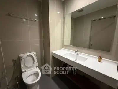 Modern bathroom with sleek fixtures and large mirror in a contemporary home.