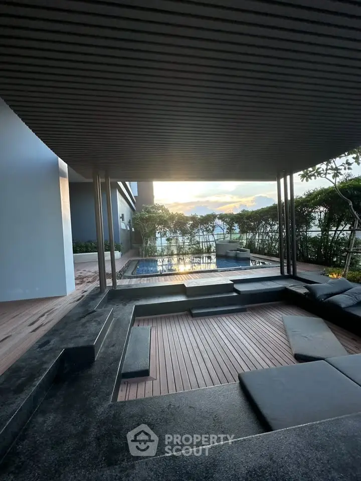 Luxurious outdoor pool area with modern seating and stunning sunset view, perfect for relaxation and entertainment.