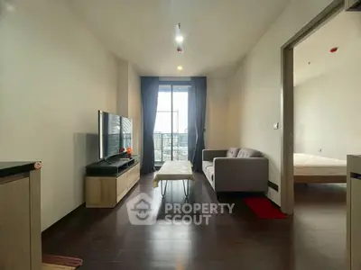 Modern living room with sleek furniture and large window offering city view