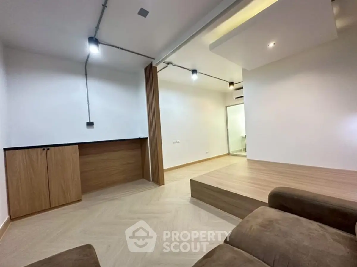 Modern minimalist living room with wooden flooring and recessed lighting