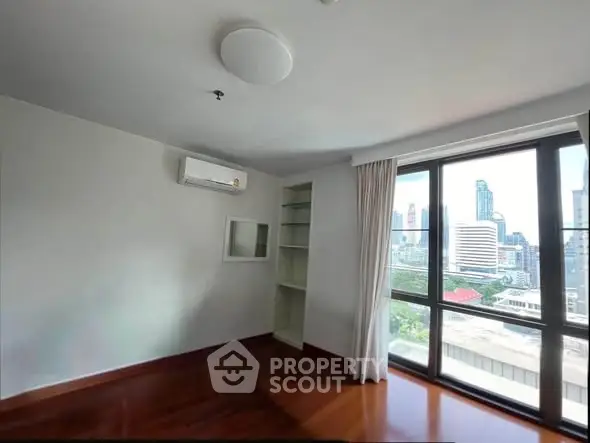 Spacious room with large windows offering stunning city views, perfect for modern living.