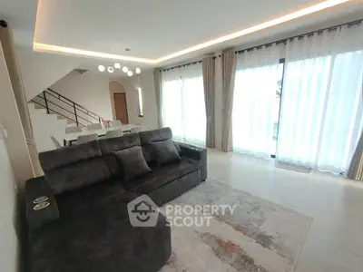 Spacious modern living room with elegant lighting and large windows for natural light.