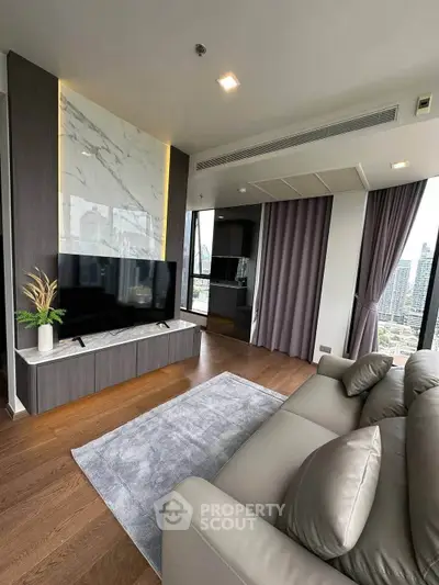 Luxurious living room with modern decor and stunning city view, featuring a sleek TV setup and elegant furnishings.