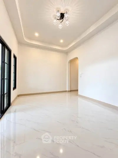 Spacious and elegant living room with modern lighting and glossy tile flooring.