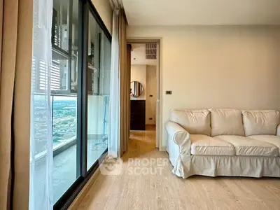 Spacious living room with cozy sofa and large window offering stunning city views.