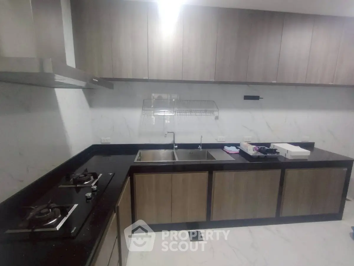 Modern kitchen with sleek cabinetry and gas stove in a contemporary apartment.