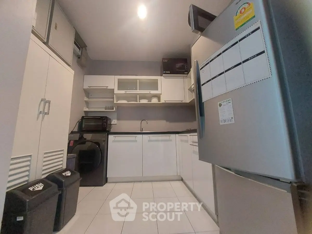 Modern kitchen with sleek white cabinets and stainless steel appliances