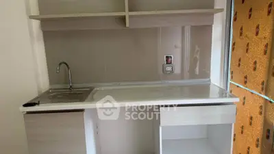 Modern kitchen with sleek countertop and open shelving, perfect for compact spaces.
