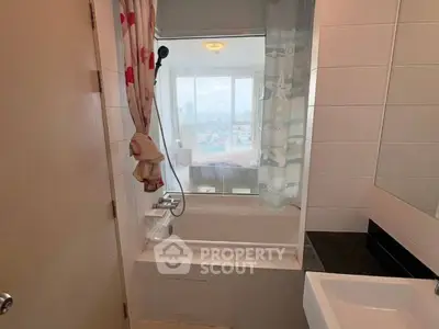 Cozy bathroom with bathtub and city view window, perfect for relaxation.