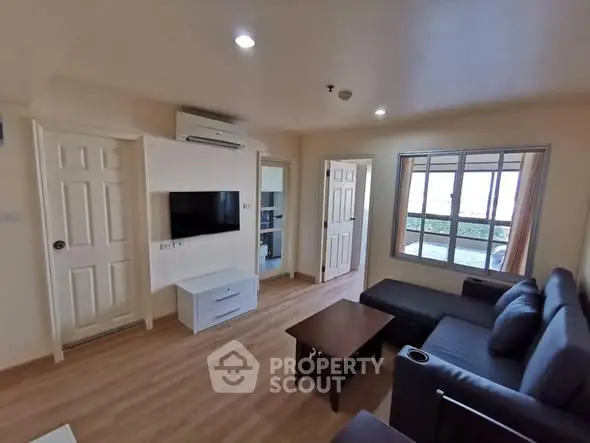 Modern living room with sleek furniture and large window for natural light.
