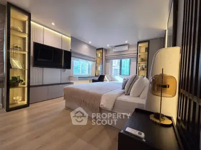 Luxurious modern bedroom with elegant decor and large windows offering city views.