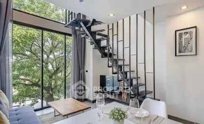 Modern living room with large windows and stylish staircase, offering a bright and airy ambiance.