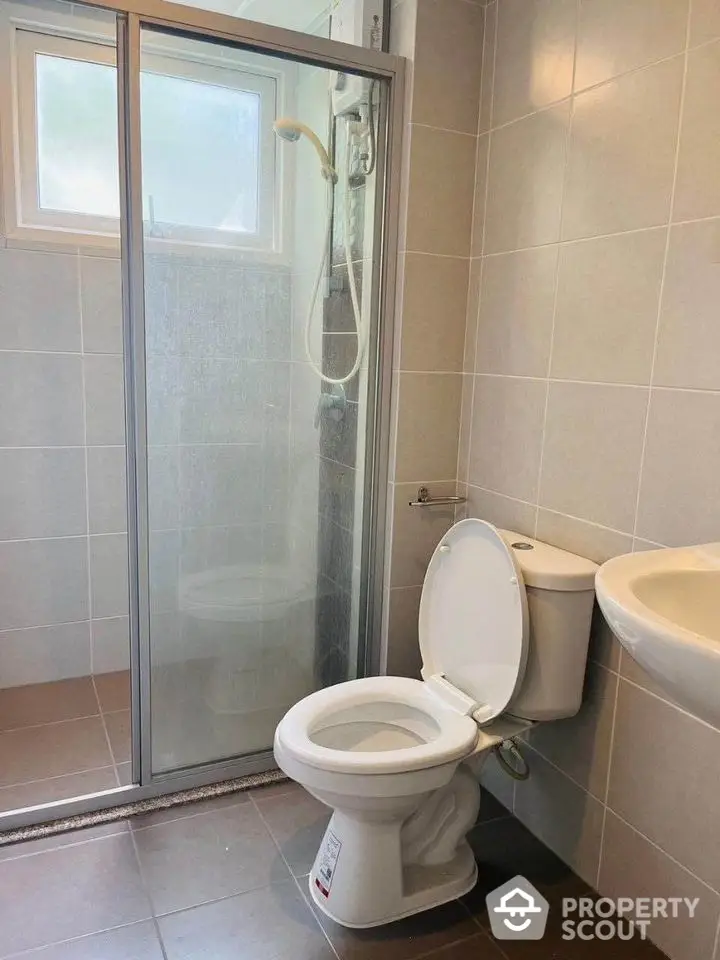 Modern bathroom with shower and toilet in sleek tiled design