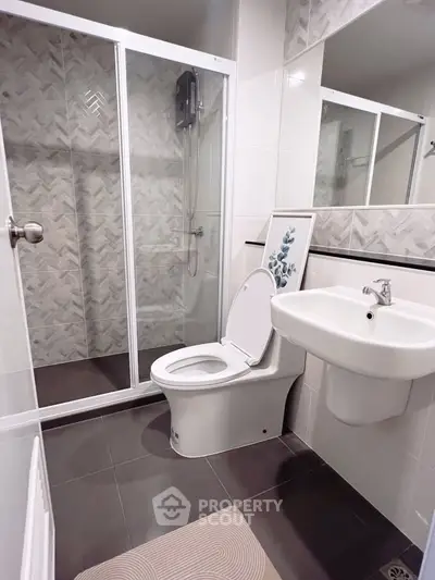 Modern bathroom with sleek shower and elegant fixtures in contemporary apartment.