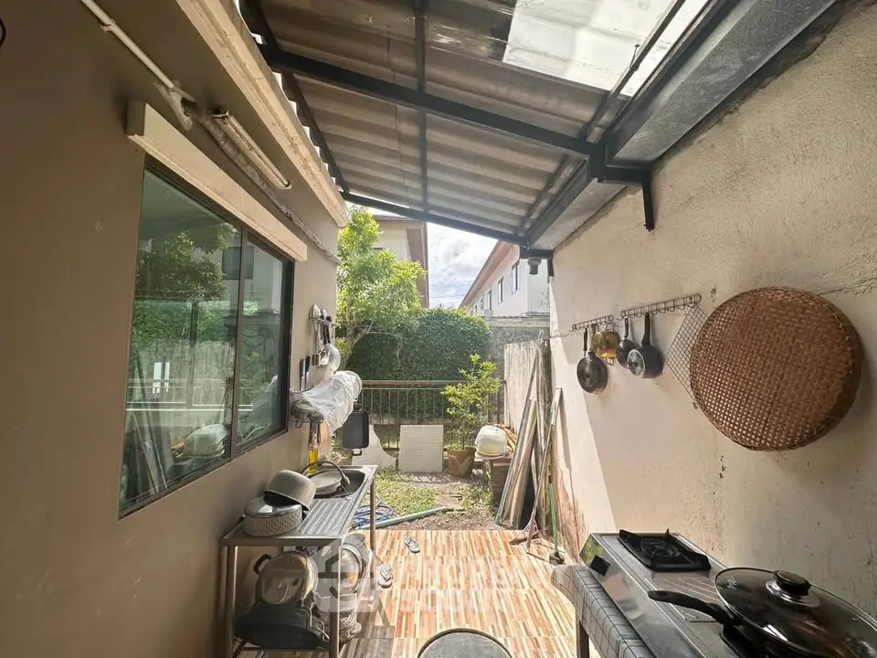 Charming outdoor kitchen with covered patio and garden view, perfect for alfresco dining and entertaining.