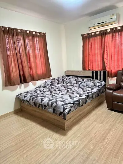 Cozy bedroom with modern bed and air conditioning, featuring stylish curtains and wooden flooring.
