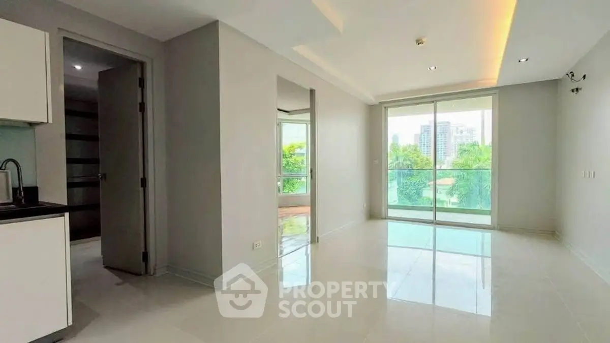 Spacious modern living room with large windows and city view, perfect for urban living.
