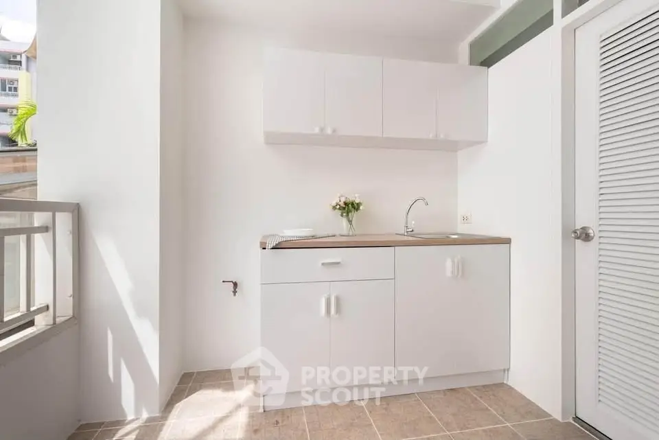 Bright minimalist kitchen with white cabinets and natural light