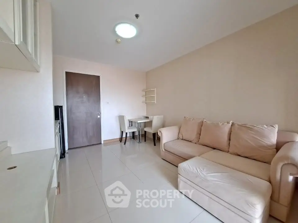 Cozy living room with beige sofa and dining area in modern apartment