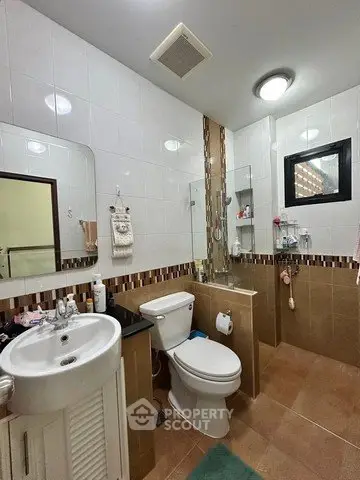 Modern bathroom with stylish tile accents and sleek fixtures, featuring a compact sink and toilet setup.