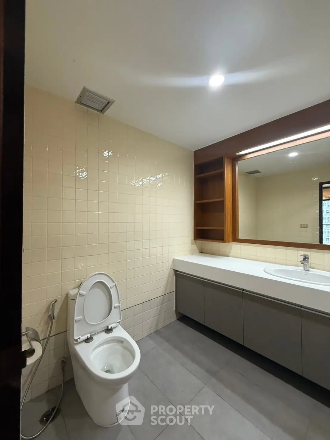 Modern bathroom with sleek vanity and large mirror in a contemporary apartment.