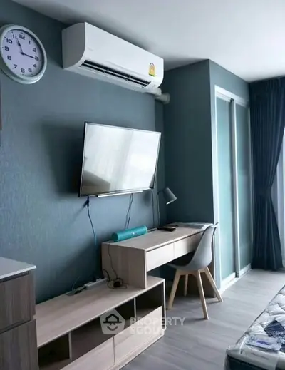 Modern study area with desk, chair, and wall-mounted TV in stylish apartment.