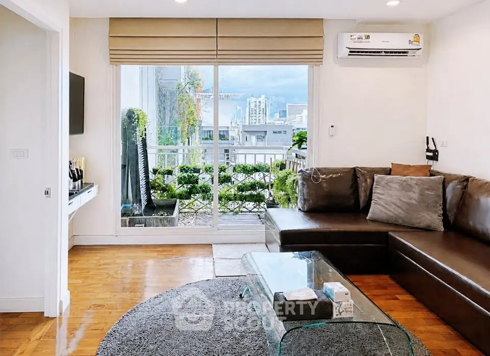 Chic living room with leather sofa, glass coffee table, and balcony view in modern apartment.
