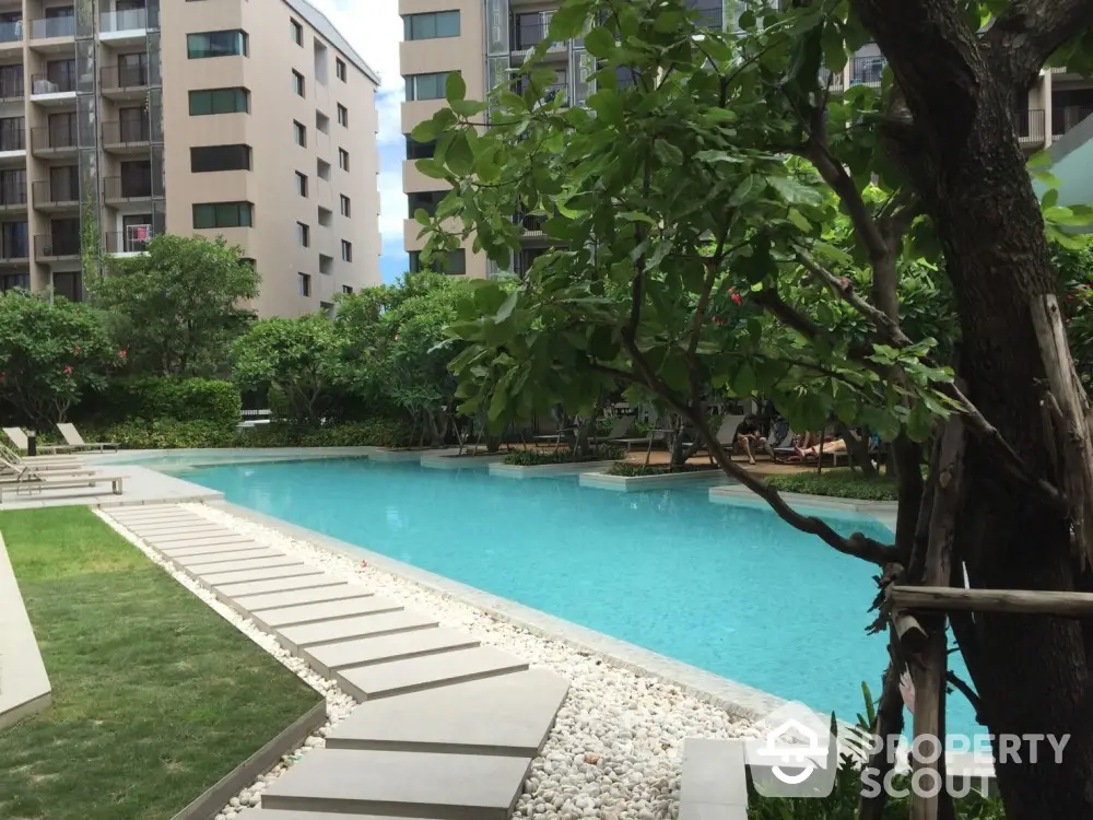 Luxurious condominium pool area with lush greenery and modern design