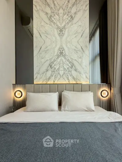 Luxurious bedroom with elegant marble accent wall and modern lighting
