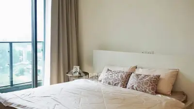 Modern bedroom with large window and stylish decor in a high-rise apartment.