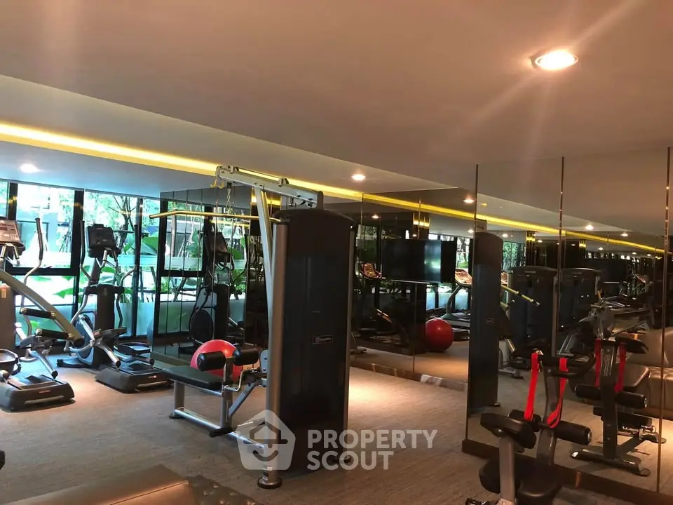 Modern gym with state-of-the-art equipment and mirrored walls in a luxury residential building.
