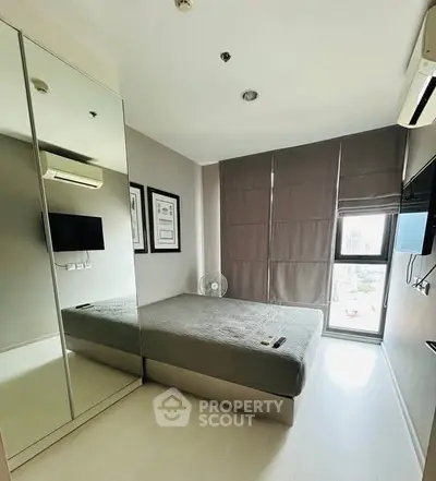 Modern bedroom with mirrored wardrobe and natural light