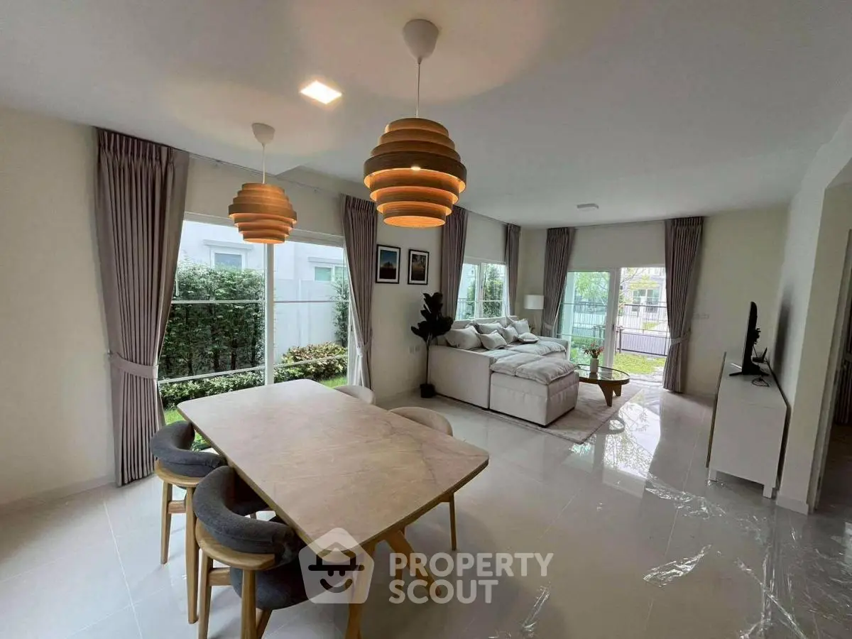 Spacious living and dining area with modern decor and garden view.