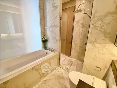 Luxurious marble bathroom with bathtub and glass shower enclosure