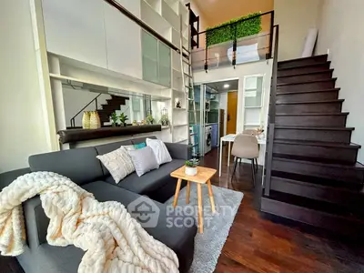Modern loft-style living room with mezzanine, sleek staircase, and cozy decor
