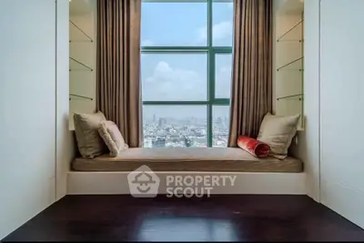 Luxurious window seat with panoramic city view in modern high-rise apartment.