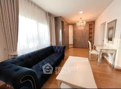 Elegant living room with plush sofa and chandelier, perfect for relaxation.