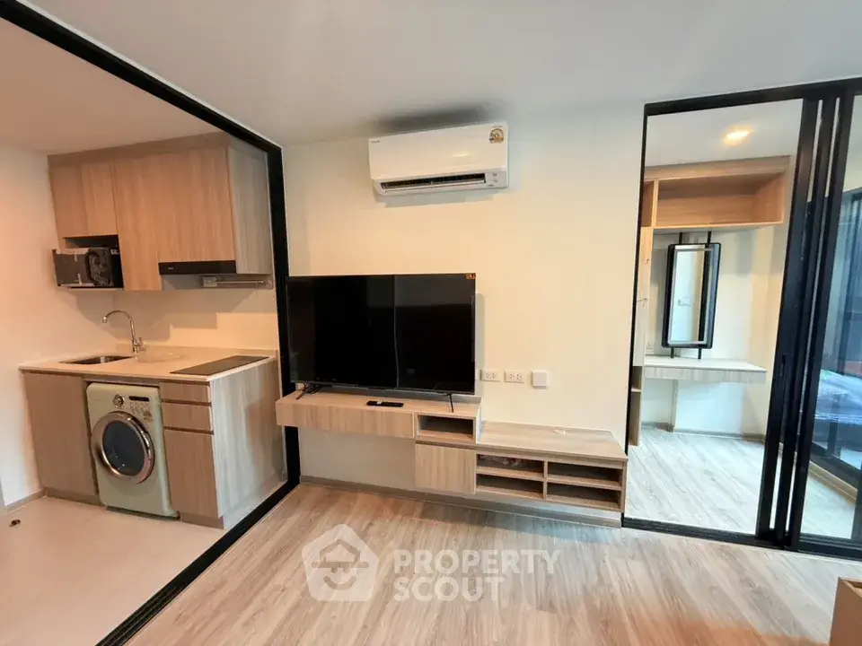Modern apartment interior with open kitchen and living area featuring sleek appliances and stylish decor.