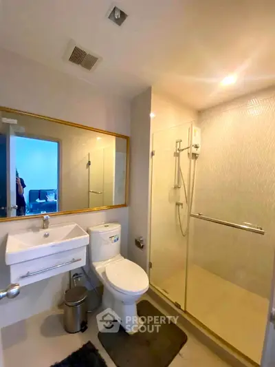 Modern bathroom with glass shower and sleek fixtures in a contemporary apartment.