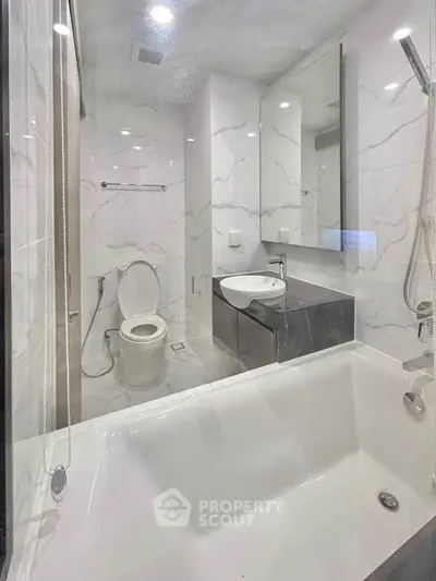Modern bathroom with sleek design, featuring a bathtub and elegant marble finishes.