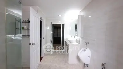 Spacious modern bathroom with dual sinks and glass shower enclosure