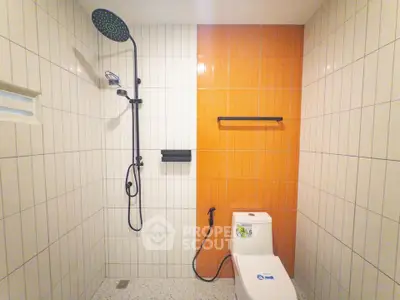 Modern bathroom with stylish shower and orange accent tiles