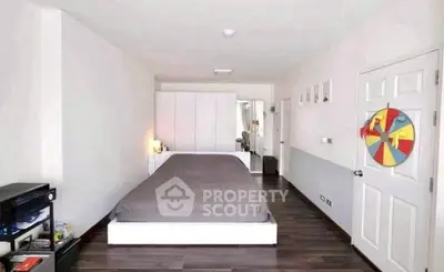 Spacious modern bedroom with sleek wooden flooring and minimalist decor