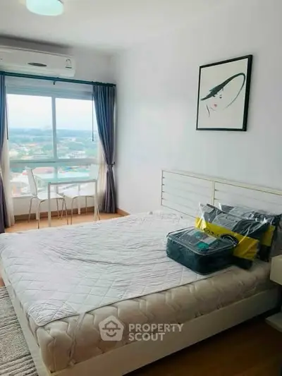 Bright bedroom with large window and scenic view, featuring modern decor and cozy ambiance.