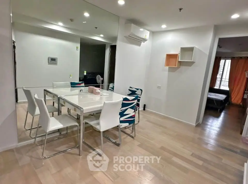 Modern dining area with stylish chairs and mirrored wall in a cozy apartment